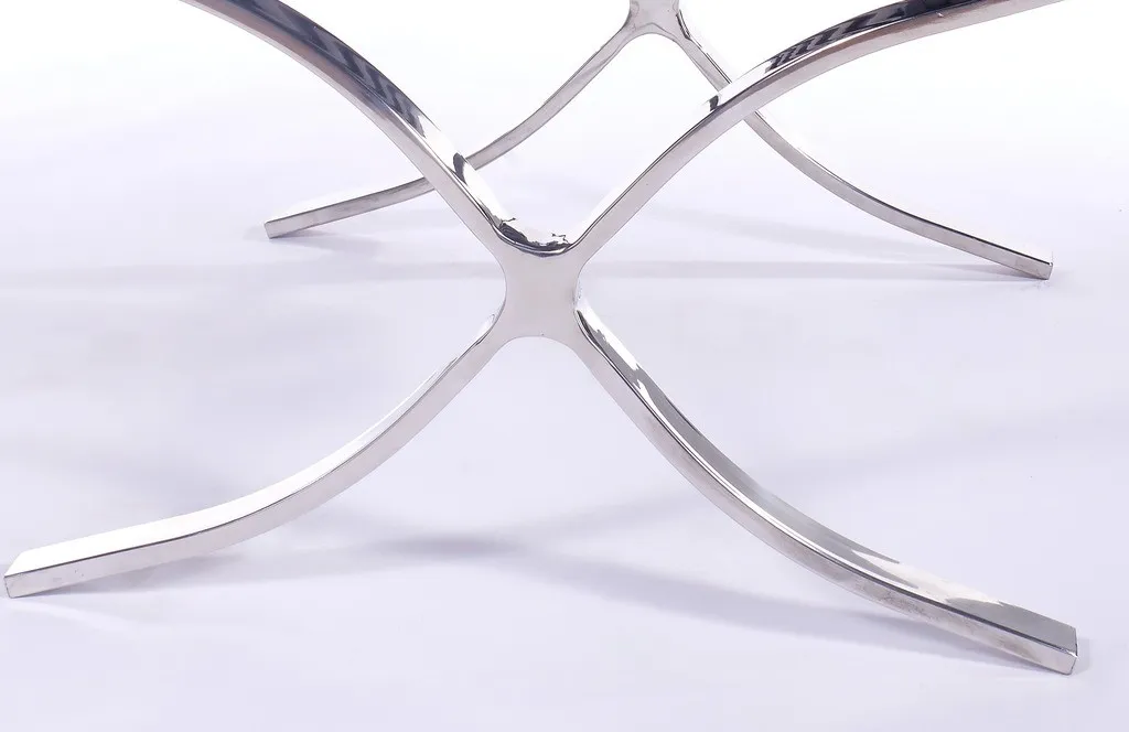 Polished steel X-frame of a grey Barcelona style chair replica, mirror finish with riveted straps.