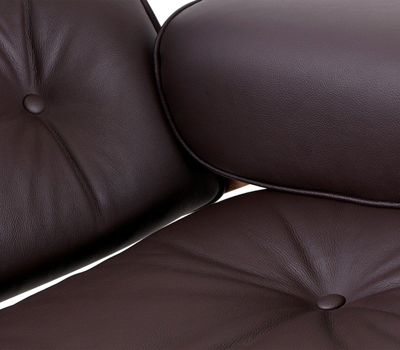 Close-up of brown leather cushions on an Eames chair, welted and hand-sewn seat and back.
