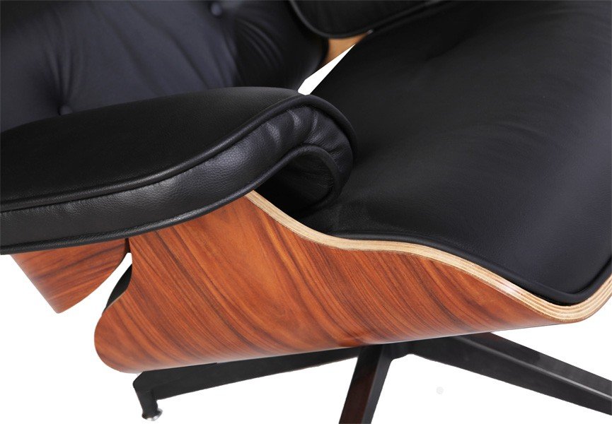 Close-up of black leather on an Eames lounge chair, showing the welted seam and soft grain.