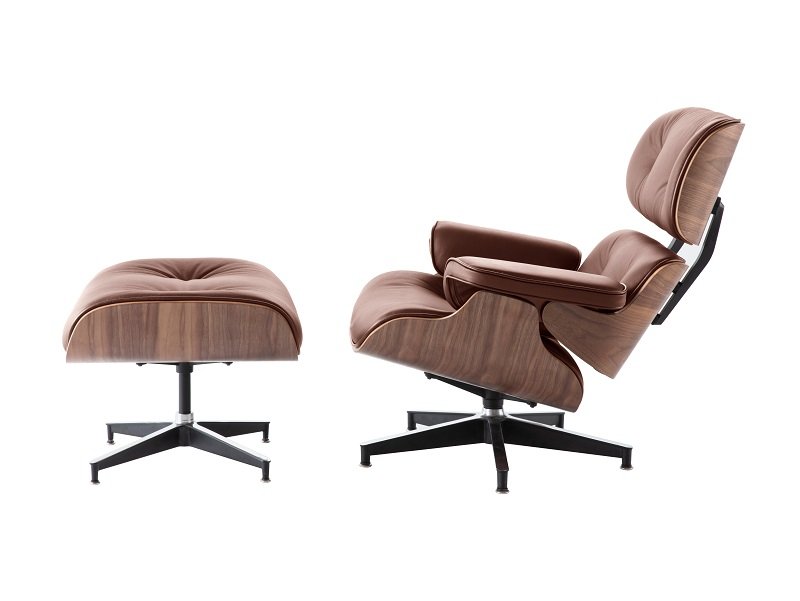 Tan Eames lounge chair and ottoman seen from the side, showing the easy recline of the walnut shell.
