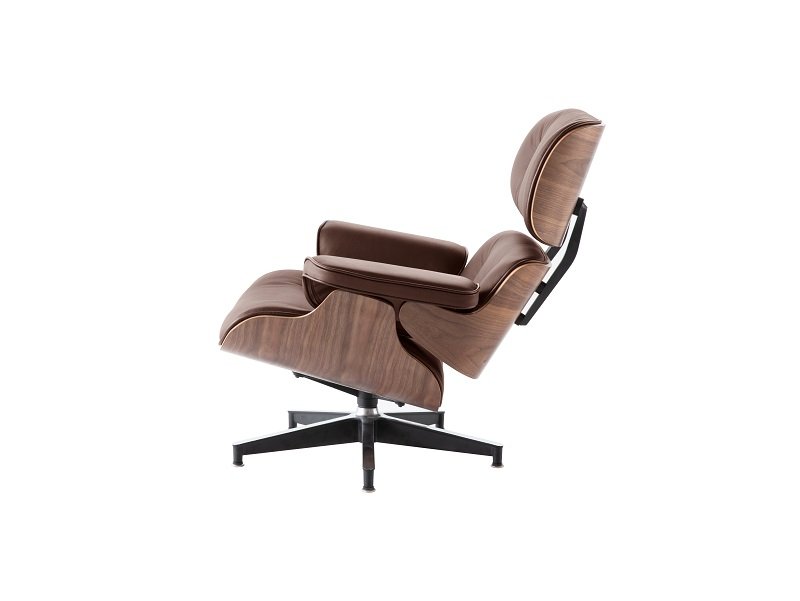 Tan Eames lounge chair seen from the side, showing the easy recline of the walnut shell.
