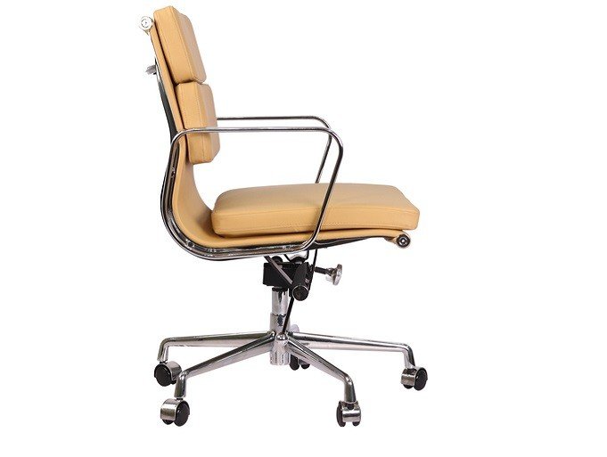 Camel Eames soft pad chair at an angle, warm leather cushions on a low-back chrome frame.